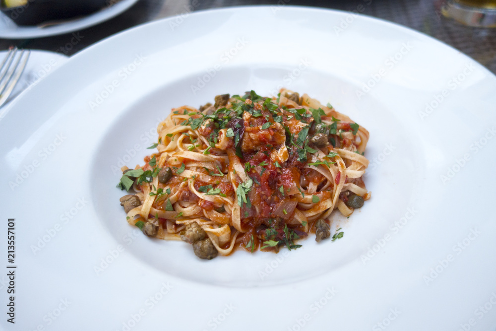 linguini pasta red tomato sauce mushrooms basil white plate restaurant 
