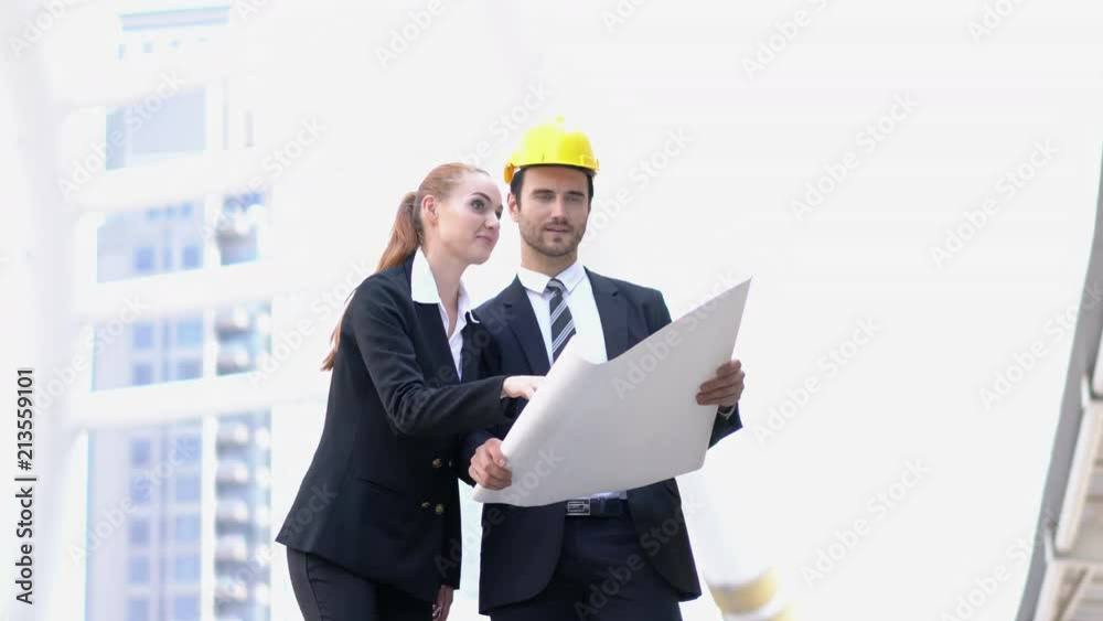 Engineer and business woman holding blueprint with talking discuss project together. Concept of project management, business meeting, strategy and engineering. Engineer and business woman holding blueprint with talking discuss project together. Concept of project management, business meeting, strategy and engineering.