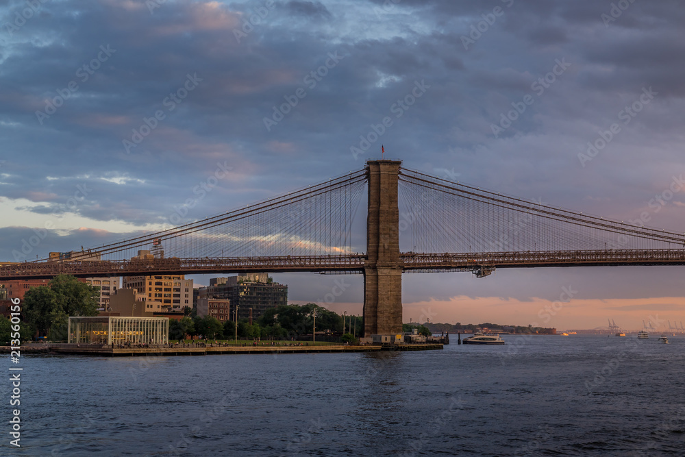 Sunset view of Brooklyn Bridge on East River, NYC