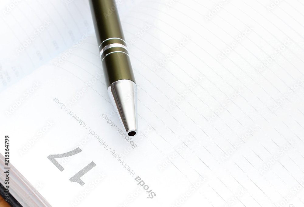 Pen lying on calendar or organizer in office Pen lying on calendar or organizer in office
