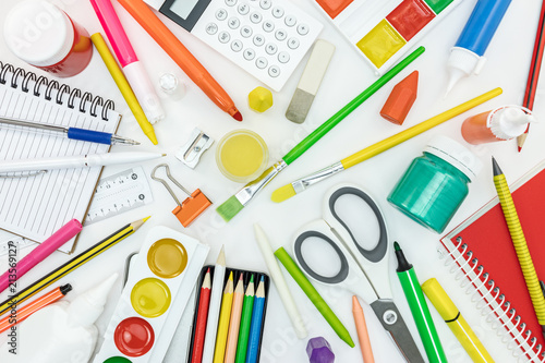 variety of school tools and office supply items on white background