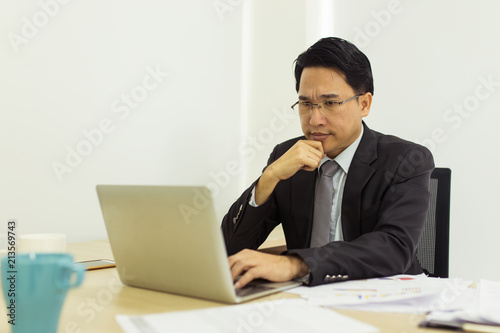 Stress businessman using laptop at his office desk.