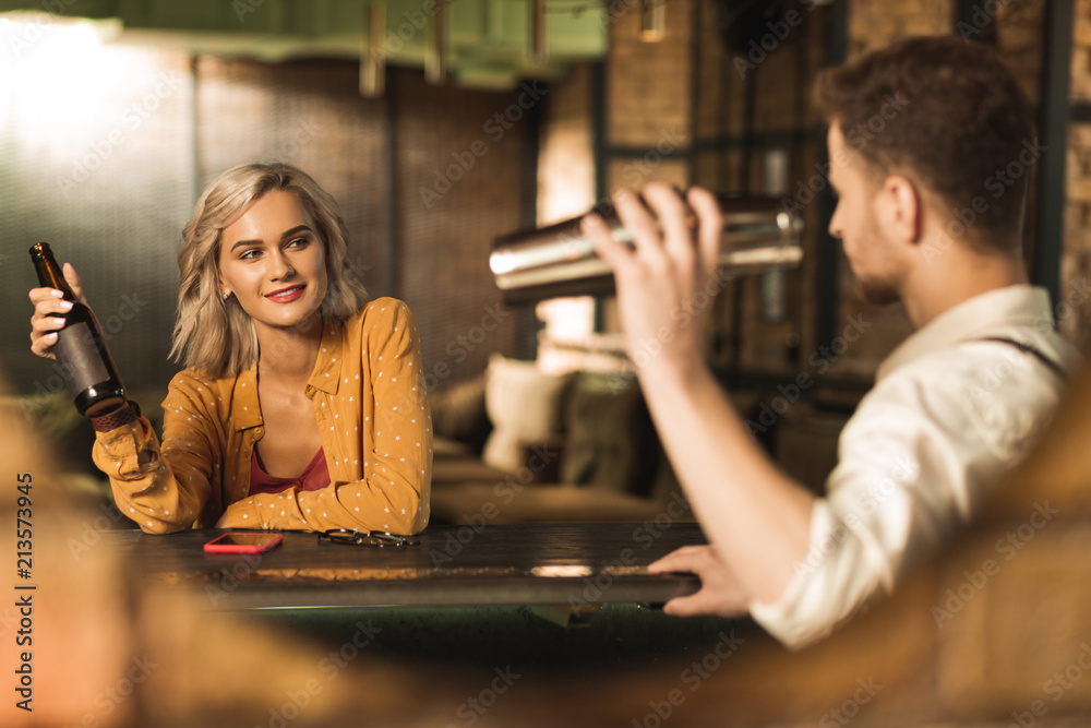 Born to flirt. Beautiful young woman sitting at the bar counter and  flirting with a barman while he making a cocktail Stock-Foto | Adobe Stock