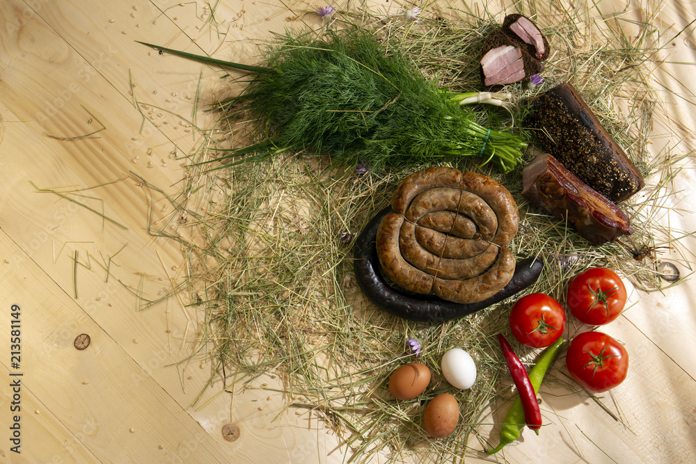 Meat and sausage cooked on organic farms, according to traditional recipes. Vegetables from the garden, eggs, food spread out on a wooden table. Meat and sausage cooked on organic farms, according to traditional recipes. Vegetables from the garden, eggs, food spread out on a wooden table.