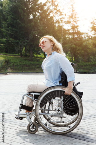 Woman in a wheelchair in the city park. The concept of an accessible environment for disabled people.