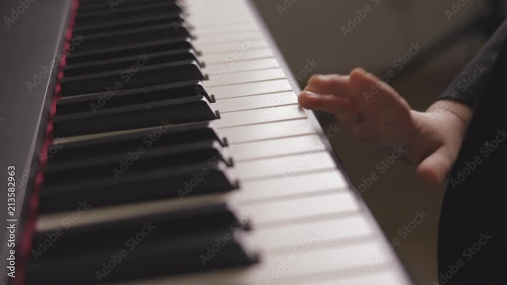 Child playing on electric piano. Side view of boy learning to play piano. Close up on piano keys, child hands and fingers. Child playing on electric piano. Side view of boy learning to play piano. Close up on piano keys, child hands and fingers.