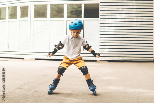 Outdoor portrait of boy with roller skates riding in the park