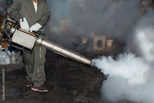 Man fogging to eliminate mosquito for prevent spread dengue fever photo