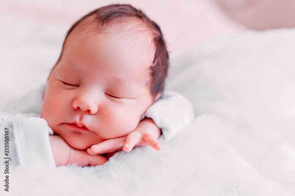 Cute newborn brunete baby sleeps lying on soft plaid Cute newborn brunete baby sleeps lying on soft plaid