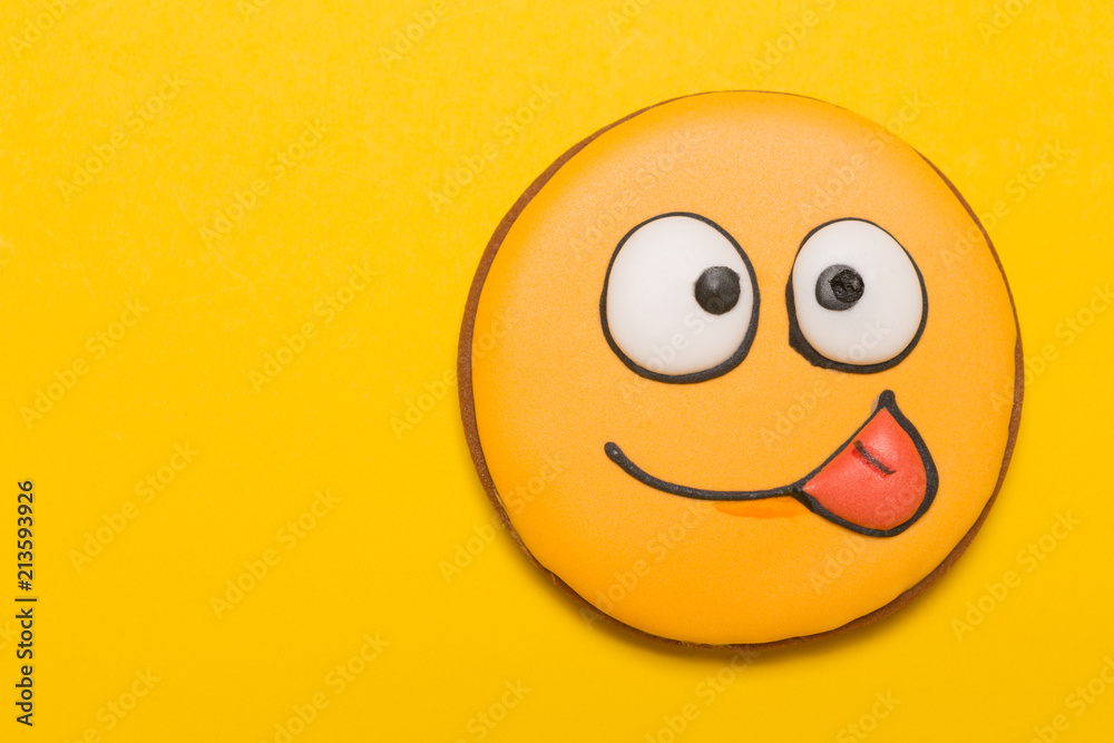 cookie smile and emotions, stick out tongue on one side, baby gingerbread, on yellow background, concept cookie smile and emotions, stick out tongue on one side, baby gingerbread, on yellow background, concept
