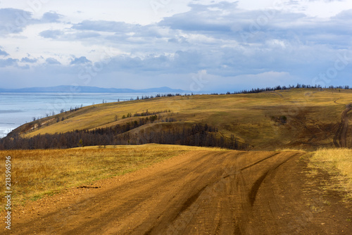 Track winding back roads in the mountains. Dirt road on Olkhon island in lake Baikal. photo