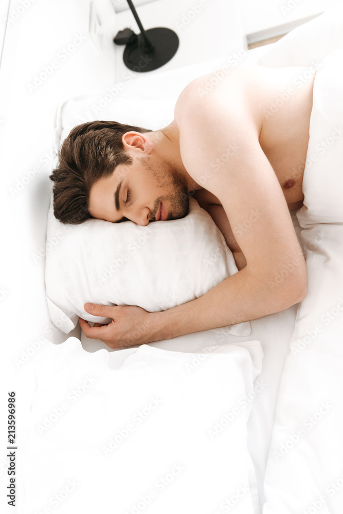 Naked man sleeping in bed indoors at home. Naked man sleeping in bed indoors at home.