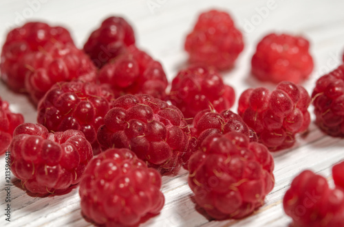 Ripe sweet raspberries on a wooden table.