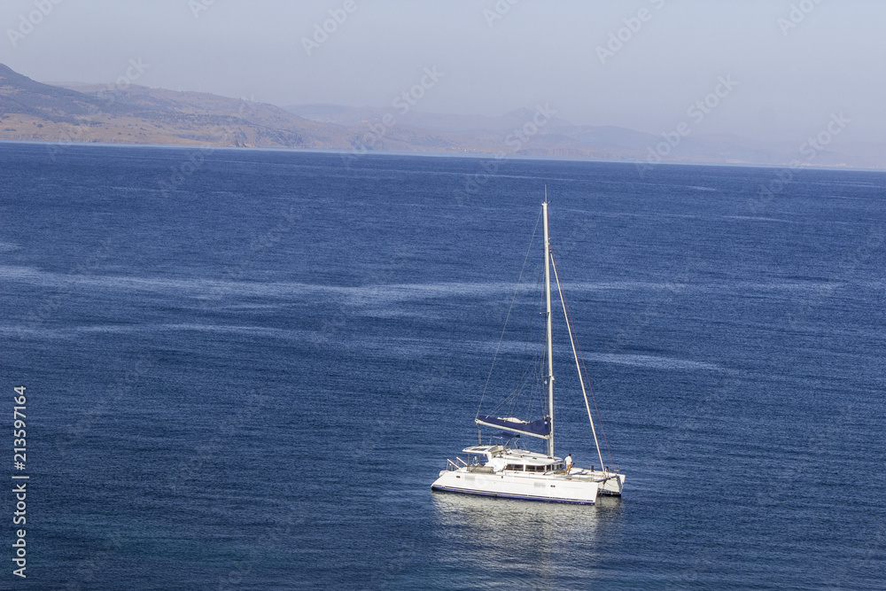 Perspective long shot of yacht on open sea waiting to sail at Plomari in Lesvos Perspective long shot of yacht on open sea waiting to sail at Plomari in Lesvos