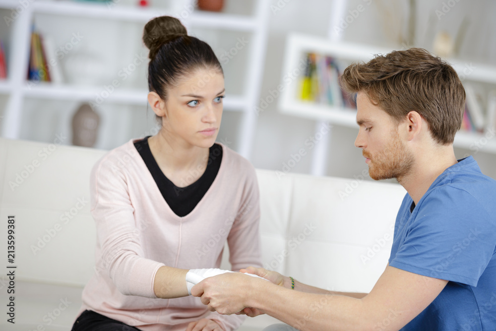 Fototapeta premium young man bandaging his girlfriends arm