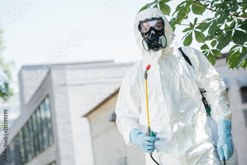 low angle view of pest control worker standing with sprayer photo