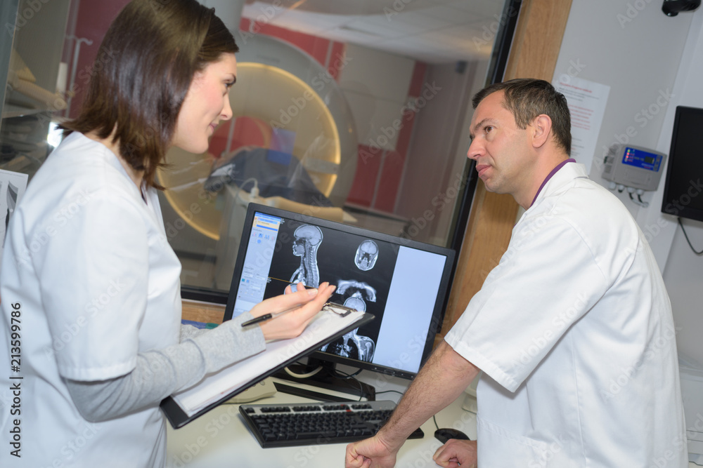 two doctor examining x-ray film of patient