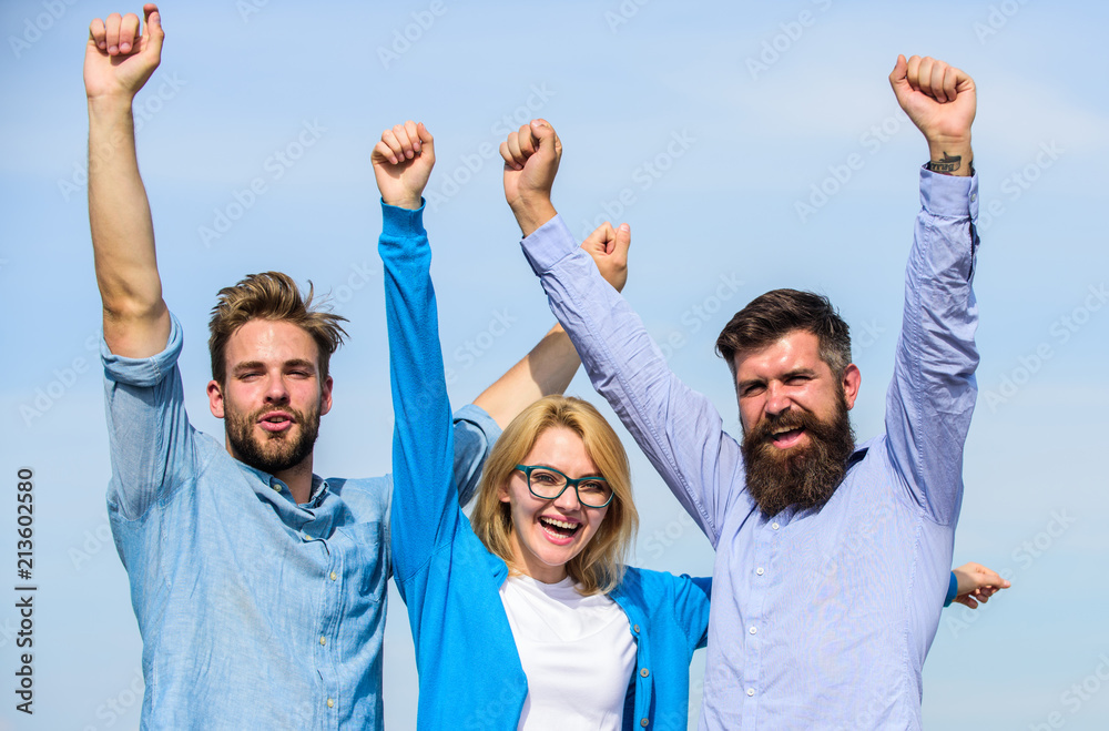 Company reached top. Men with beard in formal shirts and blonde in eyeglasses as successful team. Company of three happy colleagues or partners celebrating success, sky background. Success concept Company reached top. Men with beard in formal shirts and blonde in eyeglasses as successful team. Company of three happy colleagues or partners celebrating success, sky background. Success concept