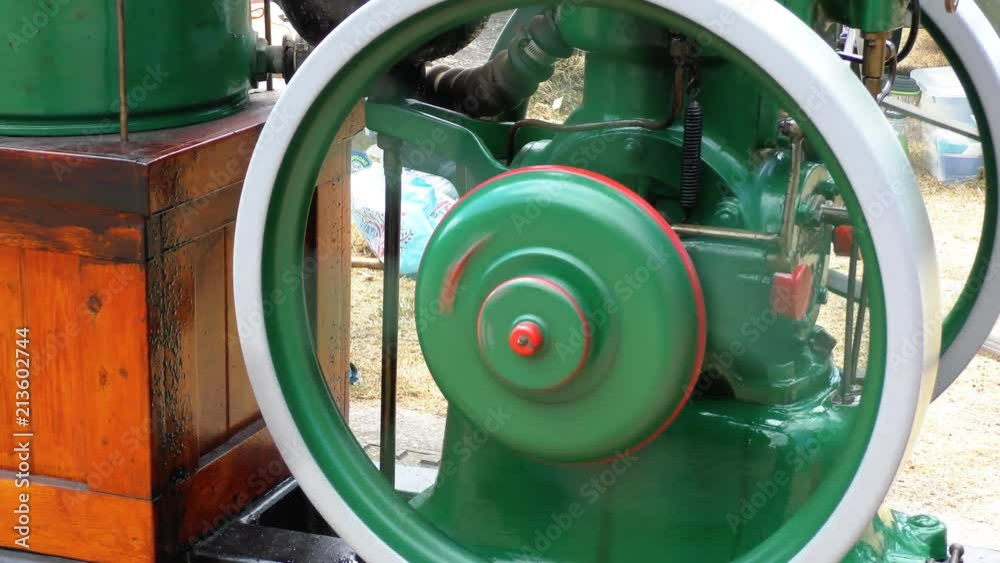Flywheel turning on a stationary engine machine pump