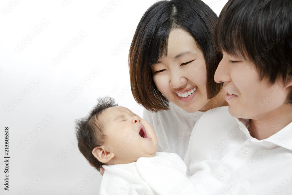 新生児を抱き見つめる若い夫婦、幸せな家族イメージ 新生児を抱き見つめる若い夫婦、幸せな家族イメージ