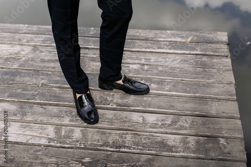 feet of groom, wedding shoes standing on Wooden Floor.