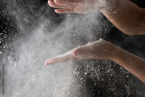 hands with flour on a black background