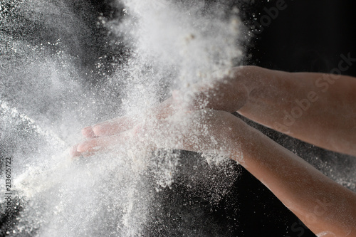 hands with flour on a black background