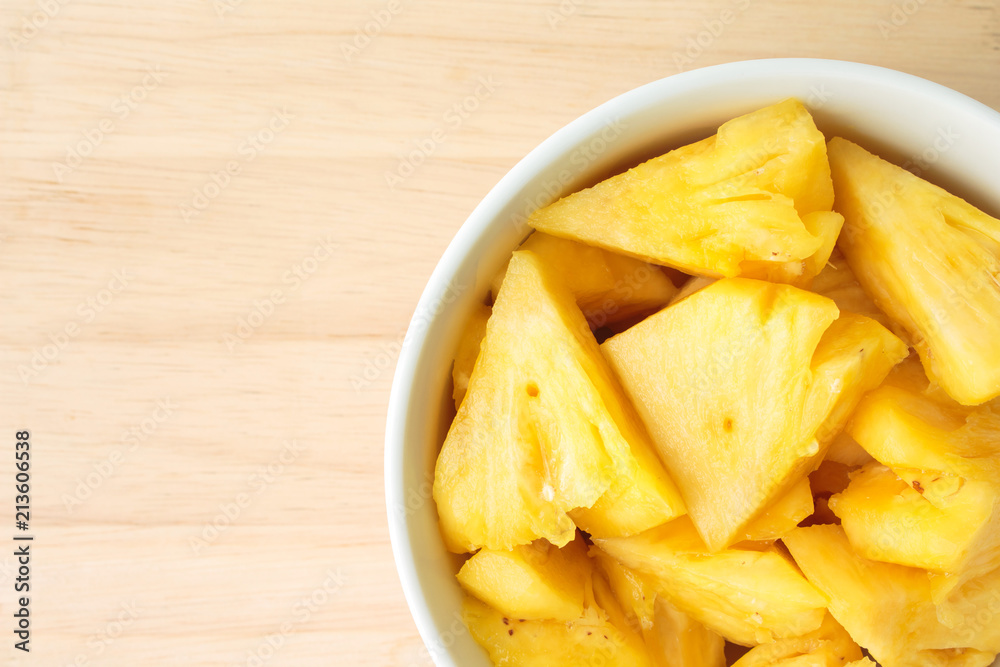 Pineapple on a plate placed on a wooden table. Pineapple on a plate placed on a wooden table.