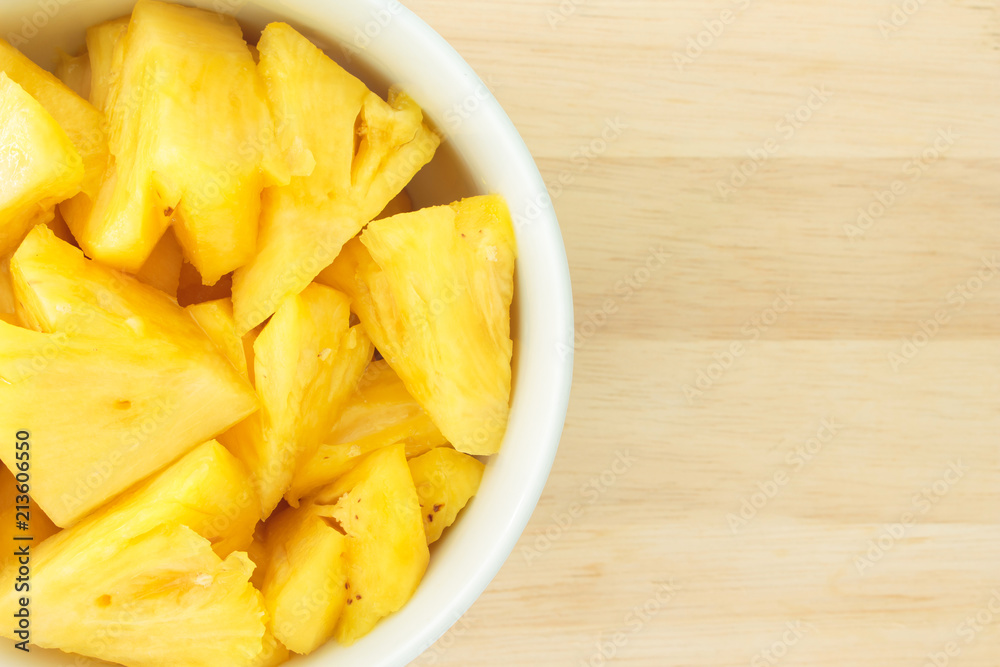 Pineapple on a plate placed on a wooden table. Pineapple on a plate placed on a wooden table.