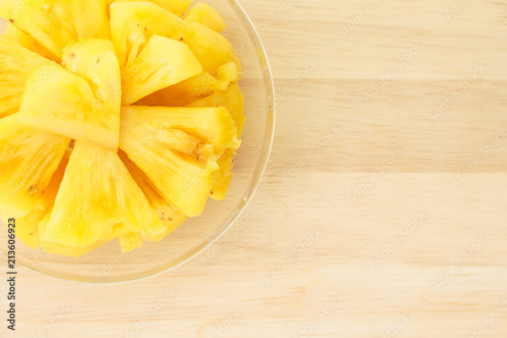 Pineapple on a plate placed on a wooden table. Pineapple on a plate placed on a wooden table.