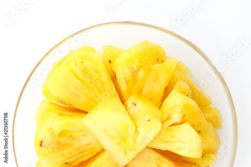Pineapple on a plate placed on a wooden table.
