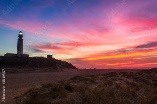 Perfect landscape with Trafalgar lighthouse on empty Zahora beach at splendid colorful sunset in Cadiz, Andalusia. Magic twilight, iconic landmark, tourism attraction, summer holidays concepts