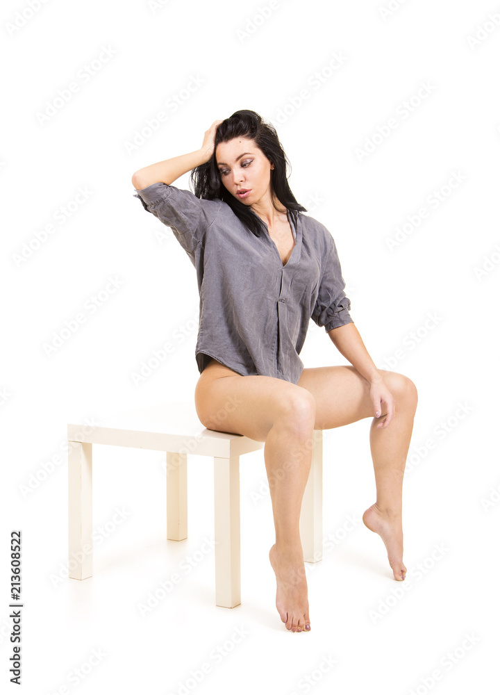 Emotional portrait of a beautiful girl with long hair, in a shirt, on a white background.