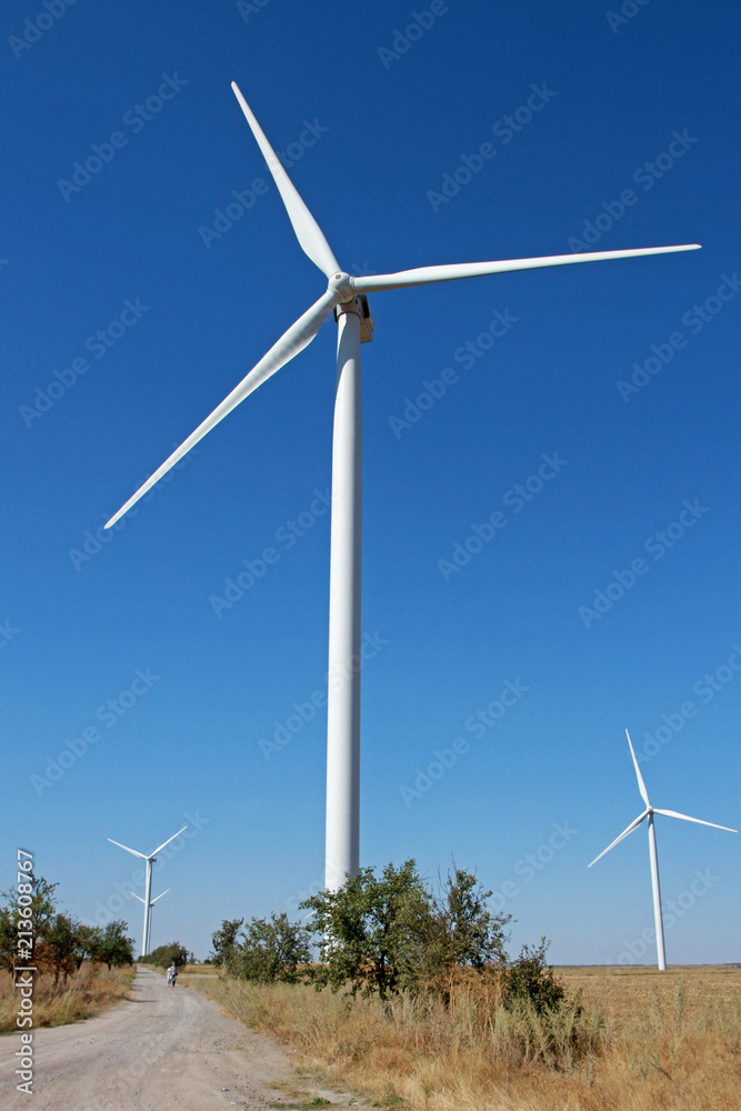 Windmills for electric power production. A wind turbine is a device that converts the wind's kinetic energy into electrical energy. Windmills for electric power production. A wind turbine is a device that converts the wind's kinetic energy into electrical energy.