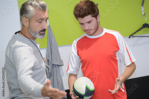 rugby player and coach talking together photo