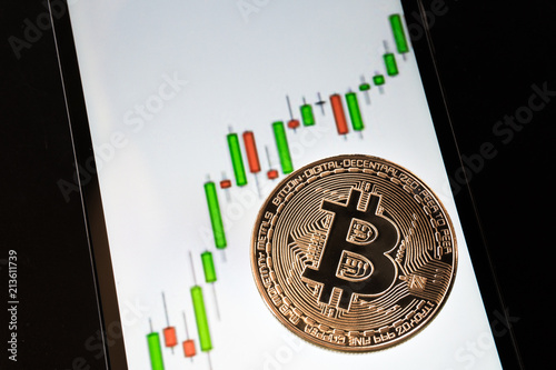 Bitcoin lying on the smartphone screen with quotes, growing trend, bullish trend, isolated