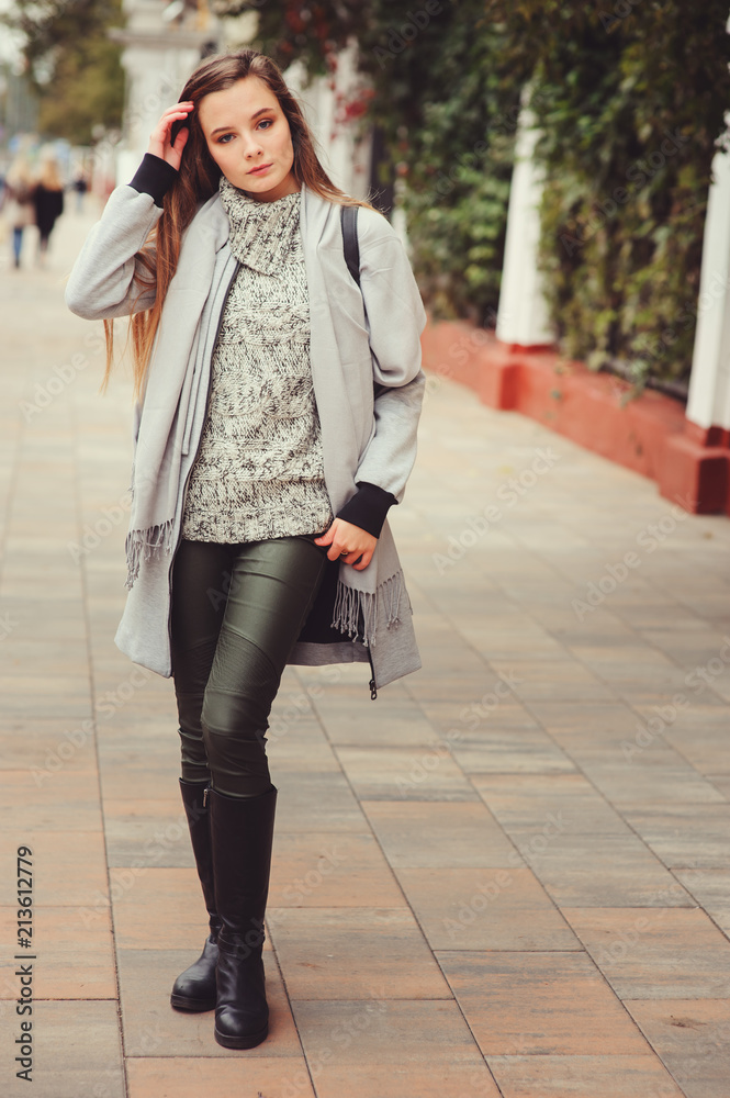 Fototapeta premium street style portrait of young beautiful happy girl walking in autumn city with trendy leather backpack