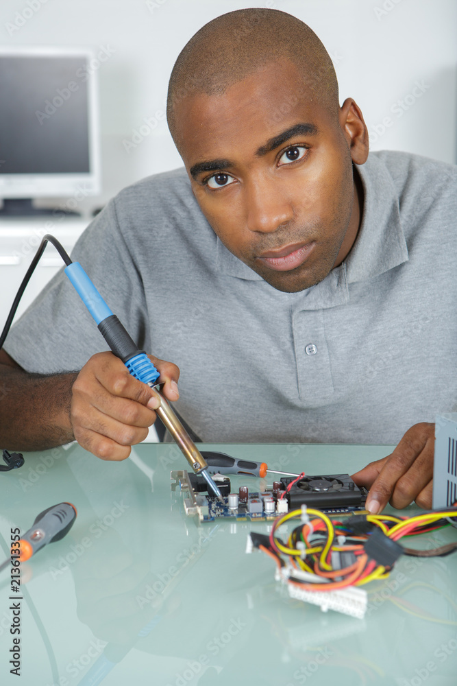 Portrait of man using soldering iron Stock-Foto | Adobe Stock