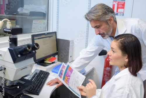 female and male eye doctor sitting with ophthalmologic device