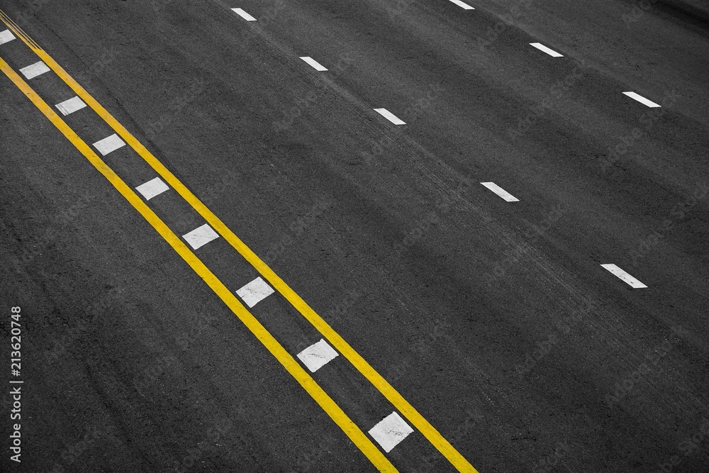 Yellow and white paint line on black asphalt. space transportation background Yellow and white paint line on black asphalt. space transportation background