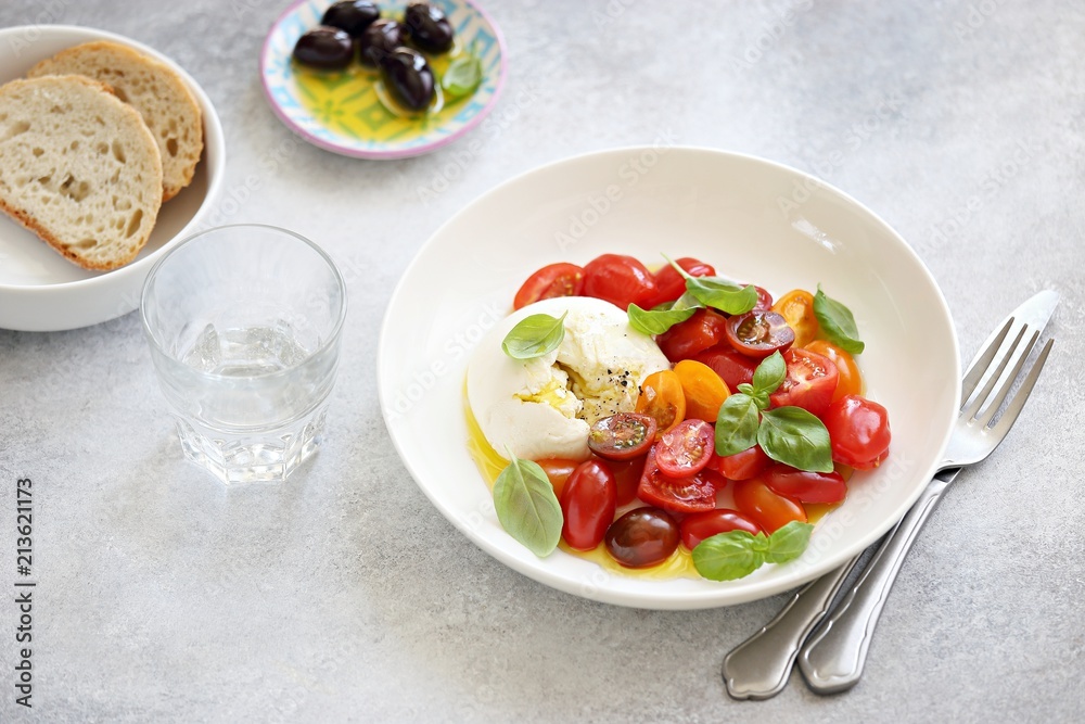 Mozzarella and cherry tomatoes salad with fresh basil and olives.
Mozzarella and cherry tomatoes salad with fresh basil and olives.