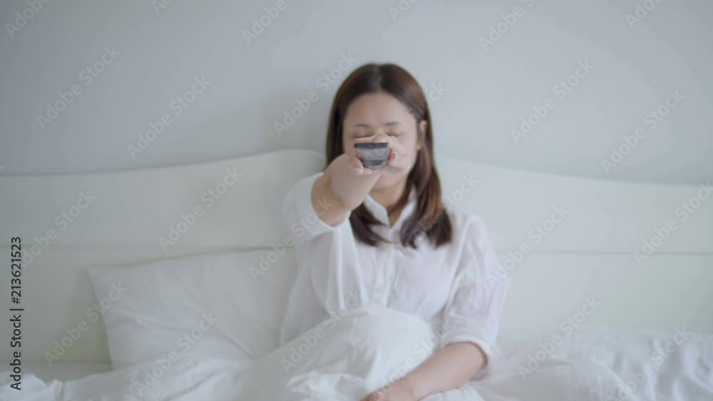 Young asian woman watching tv and clicking change channels with remote control. Young asian woman watching tv and clicking change channels with remote control.