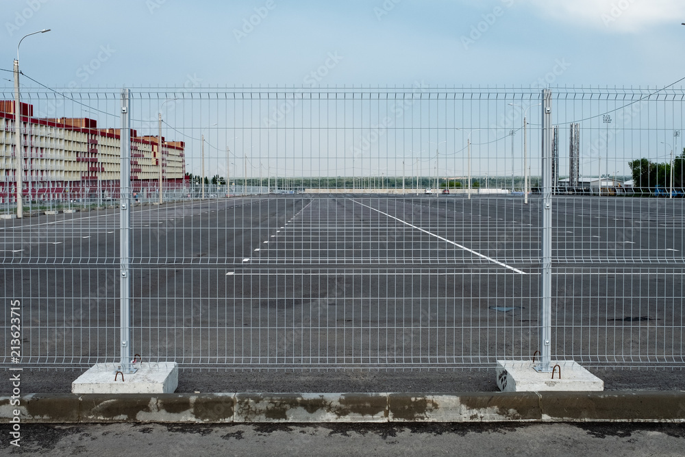 A deserted parking lot with crowds in the middle against the background of the blue cloudy sky.