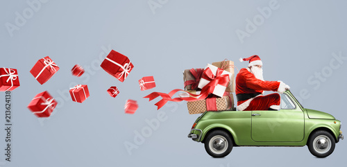Santa Claus on car delivering Christmas or New Year gifts at gray background
