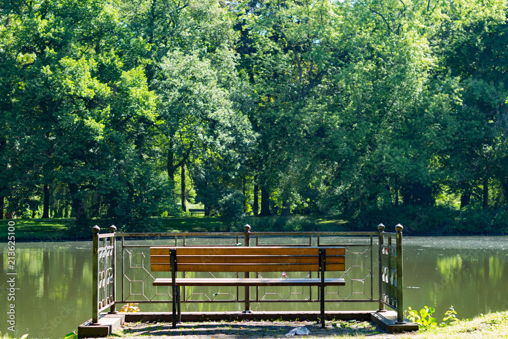 Obraz premium Leere Bank Im Park Vor See