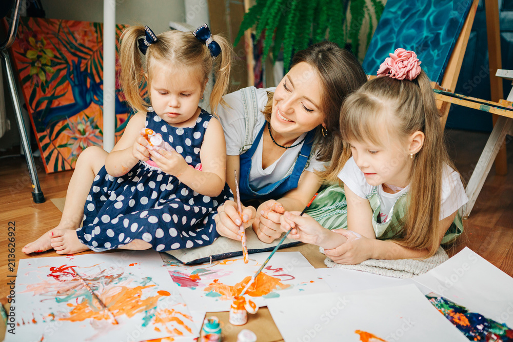Fototapeta premium Happy mom and her child playing with finger paint . Games with children with paint.Early development.Spend time with kids.