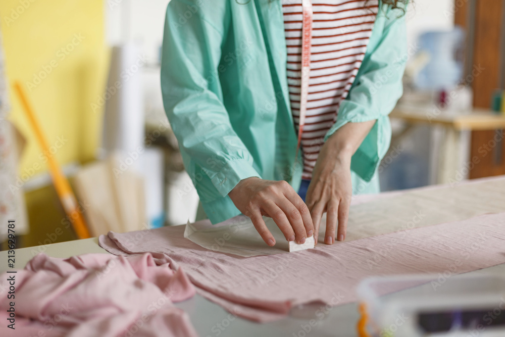 Obraz premium Close up designer of clothes drawing with soap on pink textile in sewing workshop