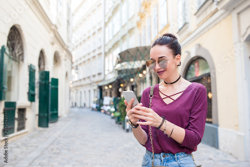 Woman talk by her smartphone in city. Young attractive tourist outdoors in italian city