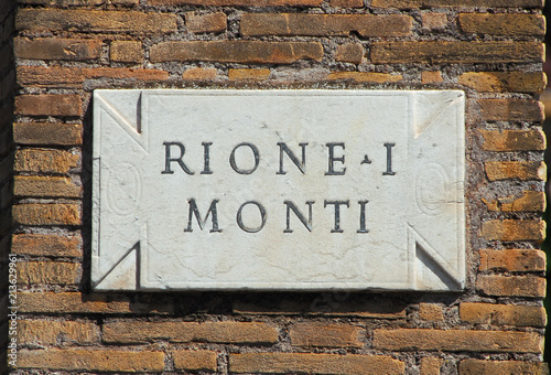 'Rione Monti', the first and most ancient district of Rome historic center, old marble slab as road sign on a brick wall