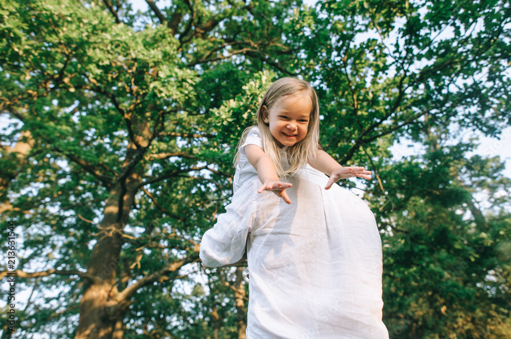 partial view of father and happy little daughter having fun together in park